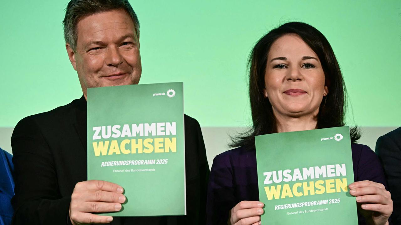 Robert Habeck und Anna Lena Baerbock halten das Wahlprogramm der Grpnen in der Hand und lächeln
